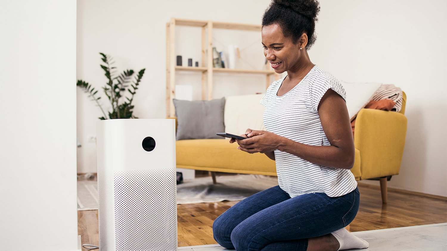 woman adjusting air purifier at home